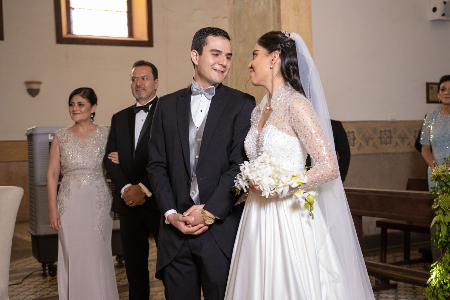 A traditional Catholic wedding ceremony taking place in an ornate church interior. Boda en Parras Coahuila, Fotógrafo de bodas