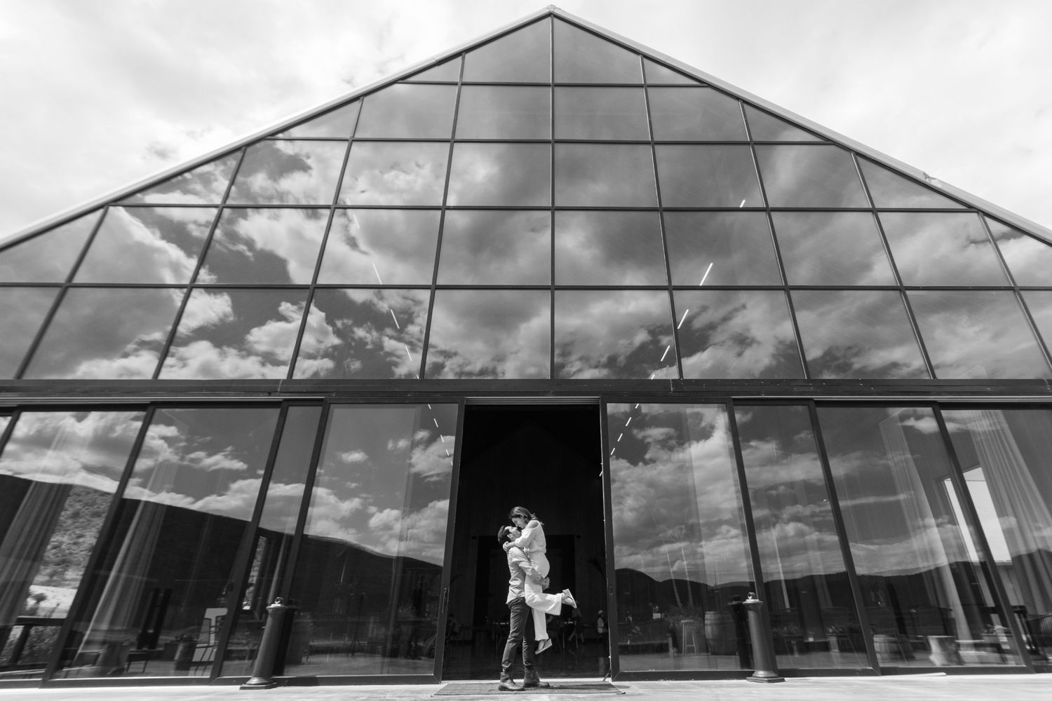 Black and white photo of modern glass building with geometric architecture and dramatic sky. boda en Parras Coahuila fotógrafo
