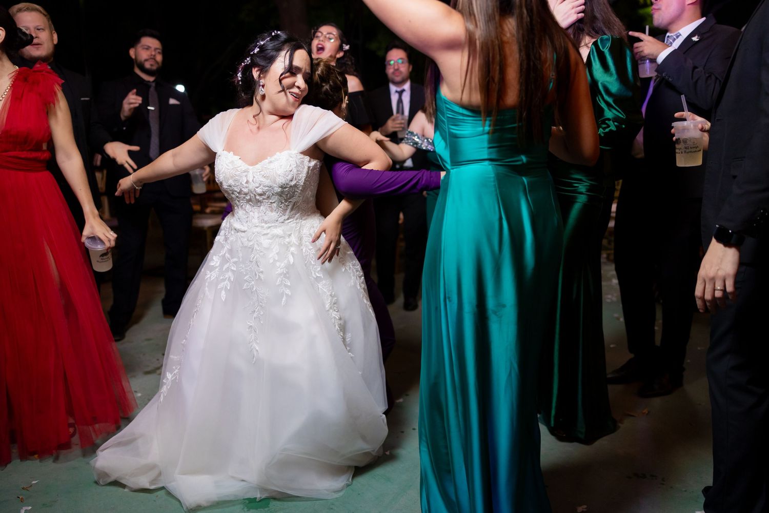 Bride in white lace dress dances among colorfully dressed wedding guests. Boda en Parras Coahuila, Fotógrafo de bodas,