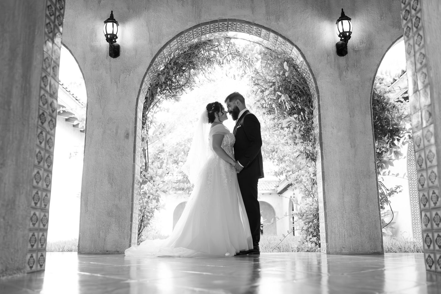 A black and white romantic silhouette of newlyweds under an elegant archway. Boda en Parras Coahuila, Fotógrafo de bodas