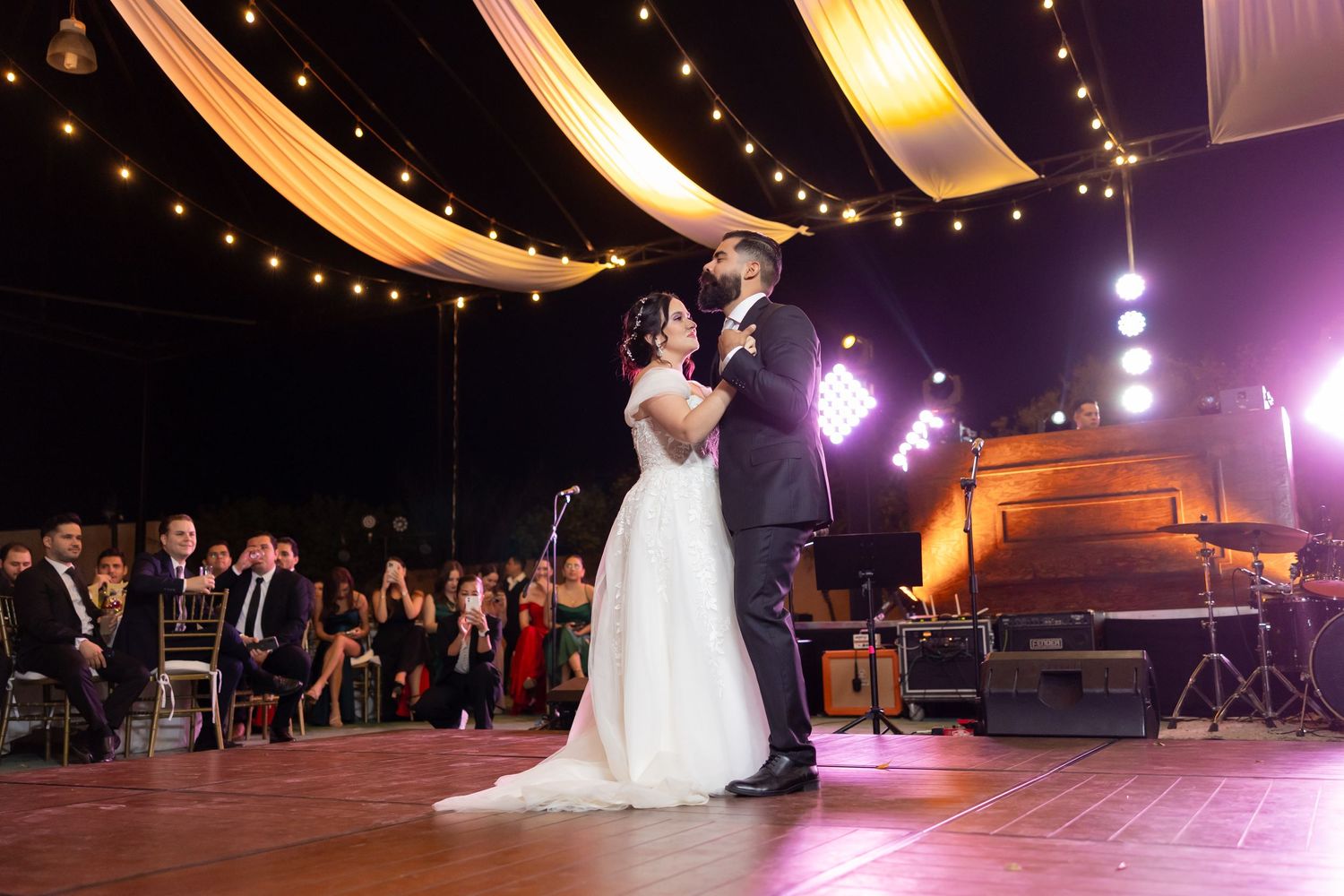 Wedding couple shares intimate dance moment under golden drapes and twinkling lights. Boda en Parras Coahuila, Fotógrafo de bodas