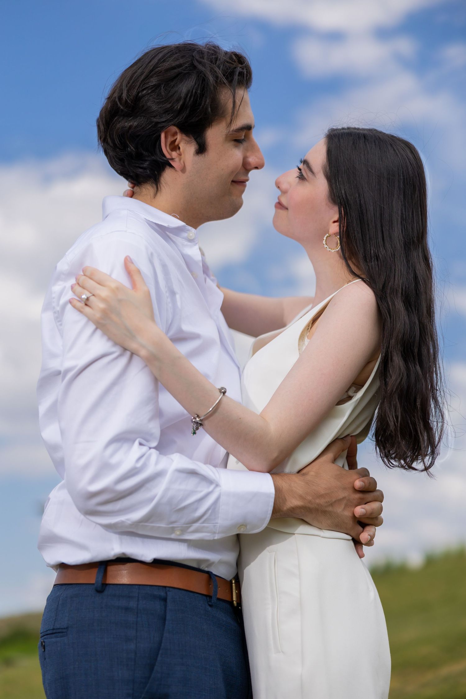 A romantic embrace captured against blue skies and white clouds. Propuesta de matrimonio Parras, Fotografo