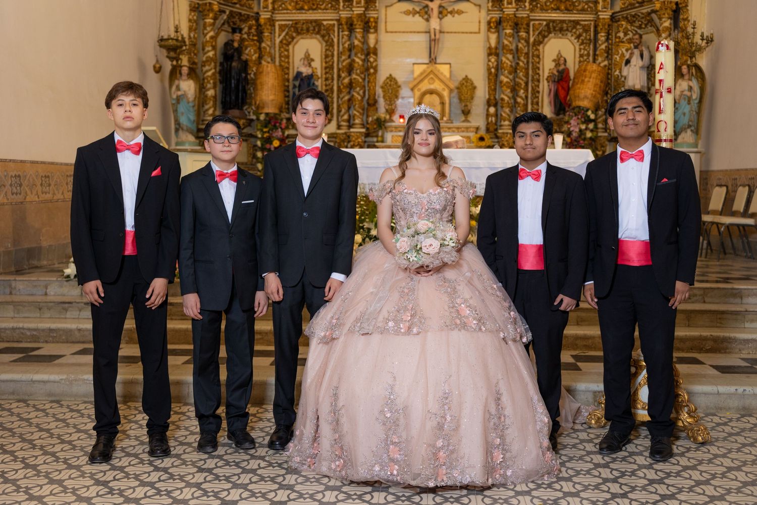 Formal group photo with groomsmen in dark suits with pink accents at church altar. Evento en Parras Coahuila , Fotógrafo Rulo