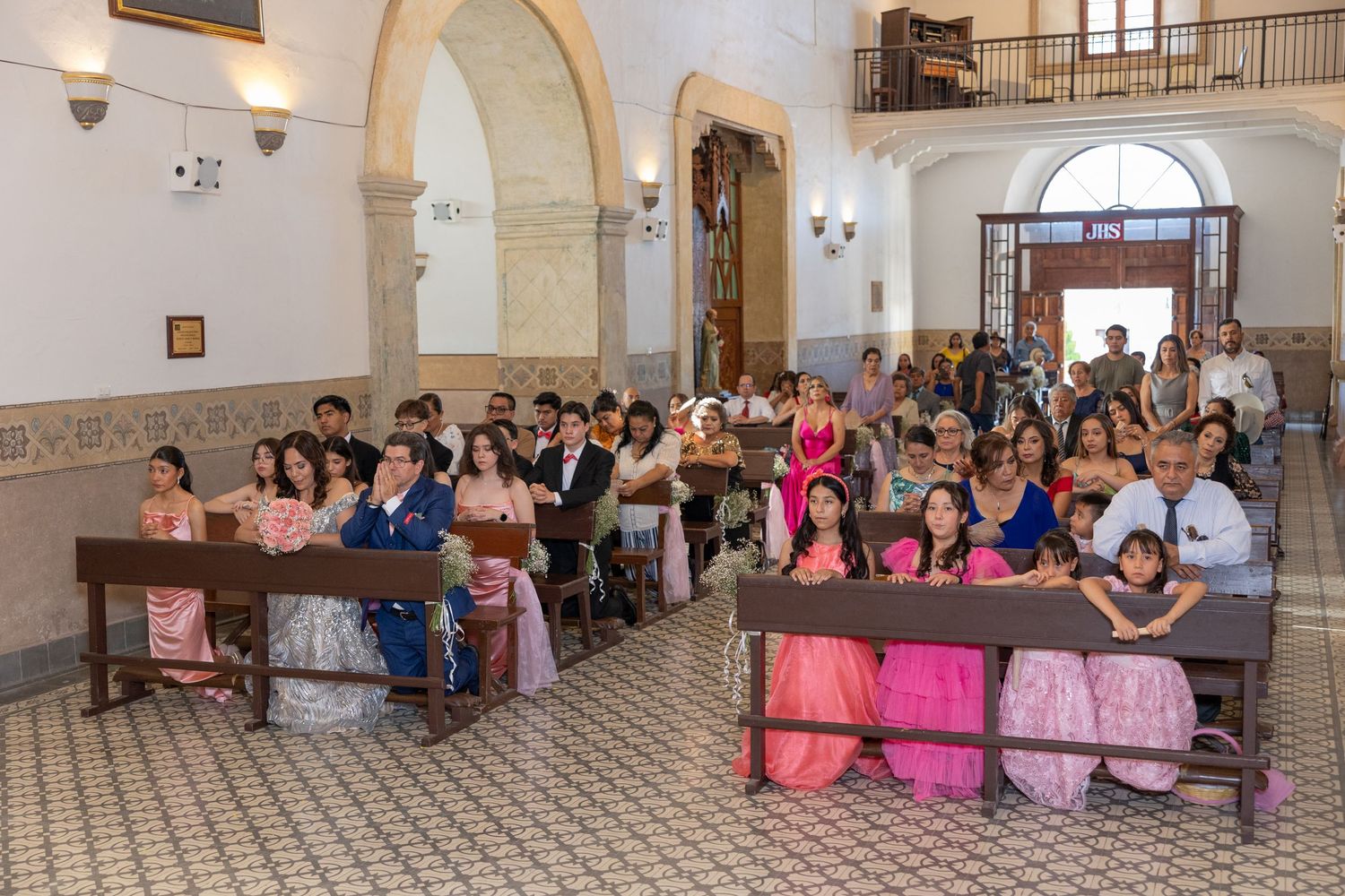 Congregation gathered in church pews under ornate arched ceilings for a special ceremony. Evento en Parras Coahuila , Fotógrafo Rulo