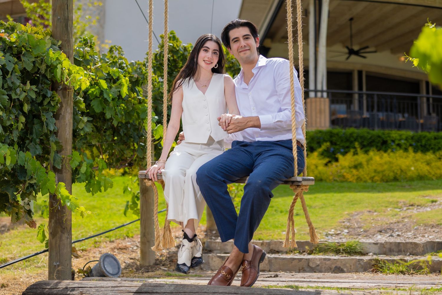 A couple shares a tender moment while sitting on a wooden swing outdoors. Propuesta de matrimonio Parras, Fotografo