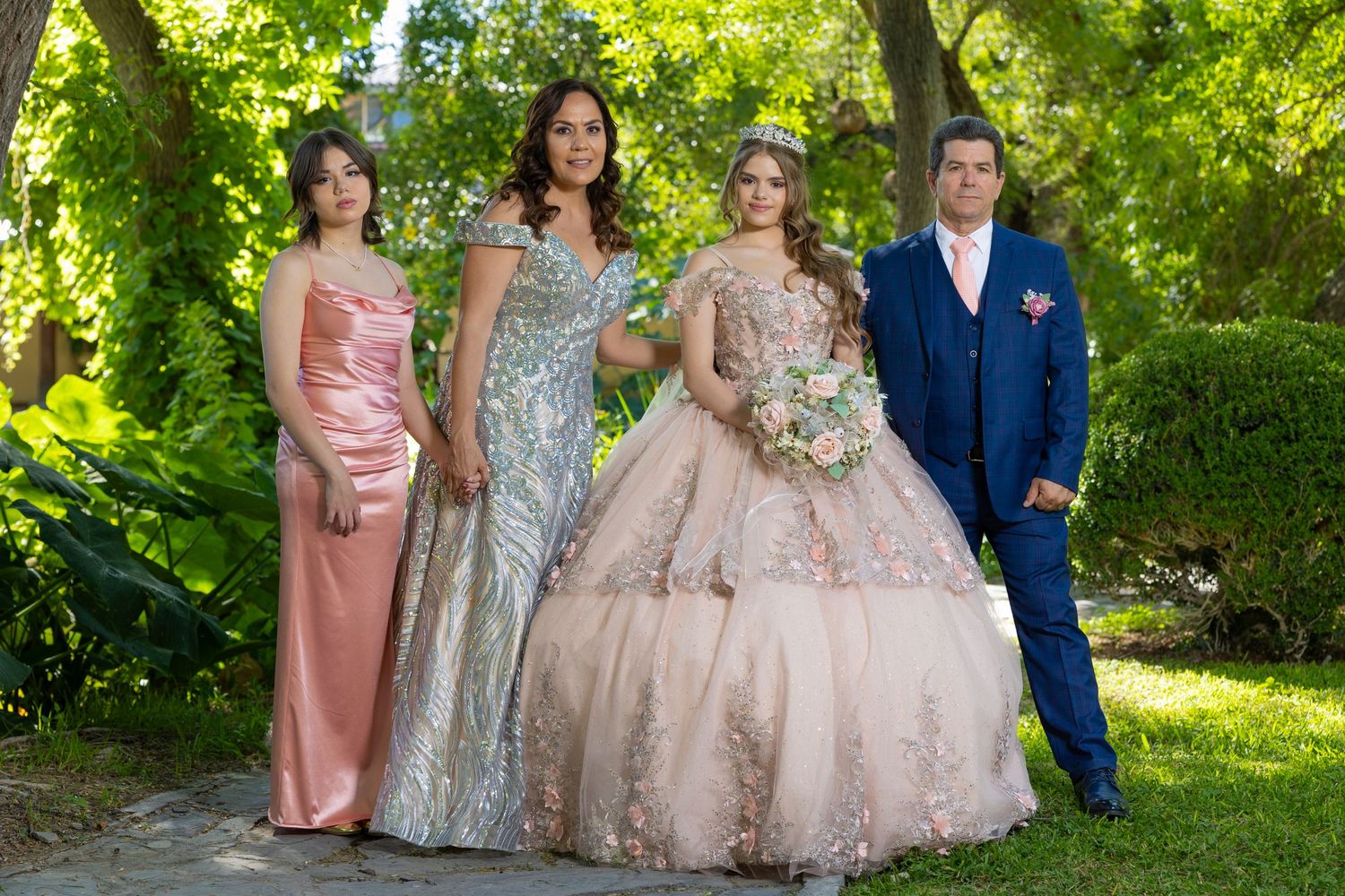 A formal group photo showcasing elegant evening wear in complementary pink and silver tones. Evento en Parras Coahuila , Fotógrafo Rulo