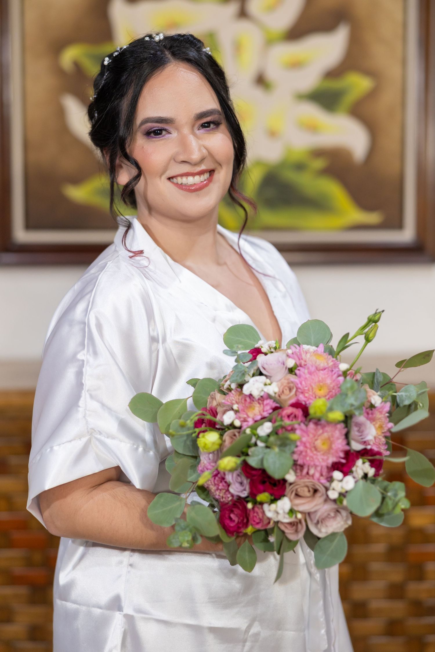 Woman in white satin robe holds pink and burgundy bouquet during wedding preparations. Boda en Parras Coahuila, Fotógrafo de bodas