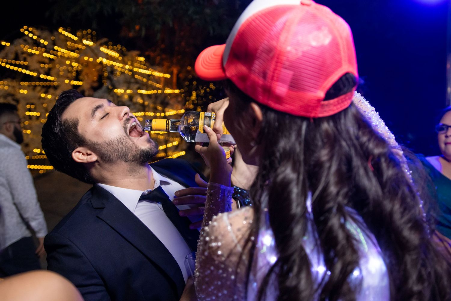 Two people share an energetic moment during a nighttime party with city lights in background. Boda en Parras Coahuila, Fotógrafo de bodas