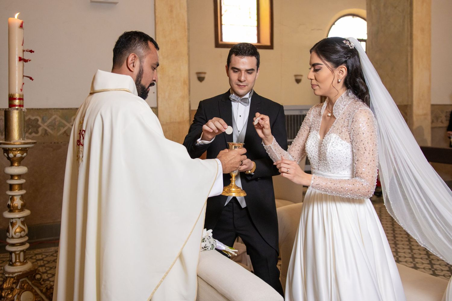 A priest performs a ring exchange ceremony during a traditional Catholic wedding. Boda en Parras Coahuila, Fotógrafo de bodas