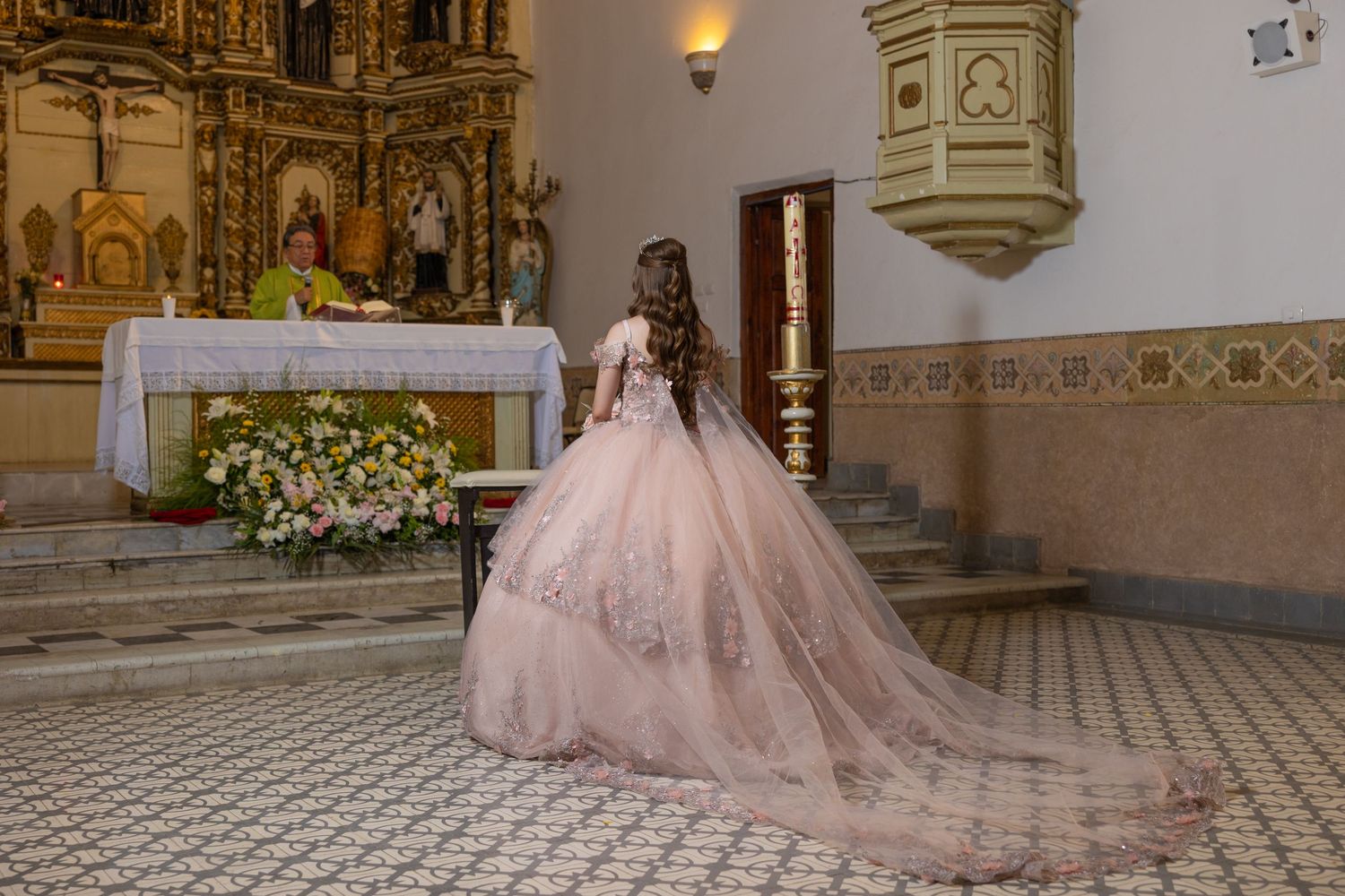A magnificent pink ball gown captured in a traditional church setting with gilded altar details. Evento en Parras Coahuila , Fotógrafo Rulo