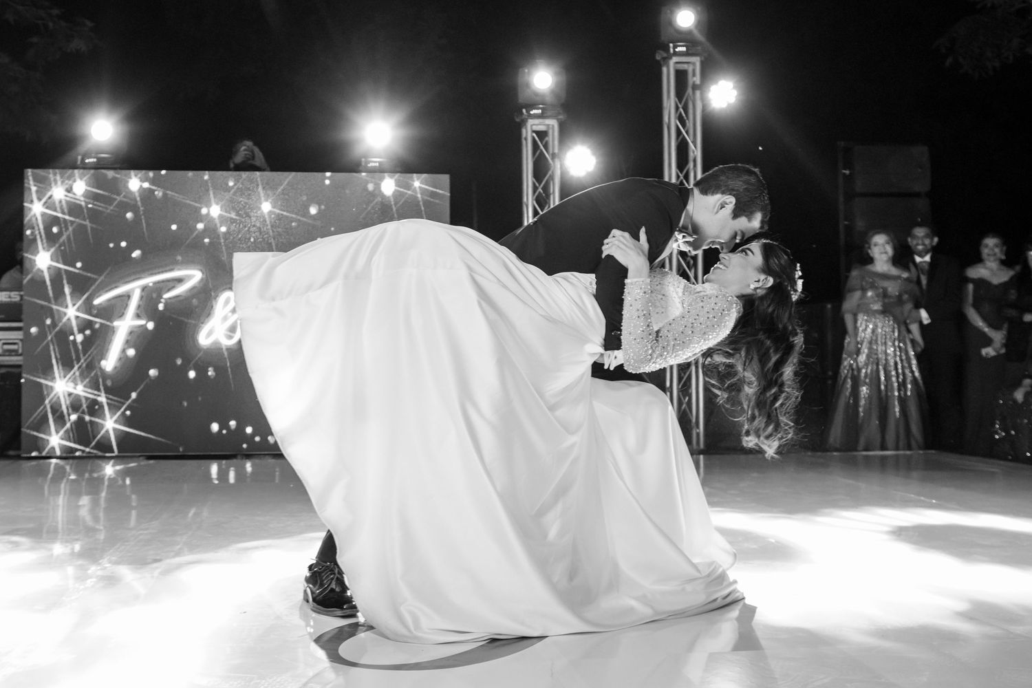 A dramatic black and white wedding dance photo captures a romantic dip on an illuminated stage. Boda en Parras Coahuila, Fotógrafo de bodas