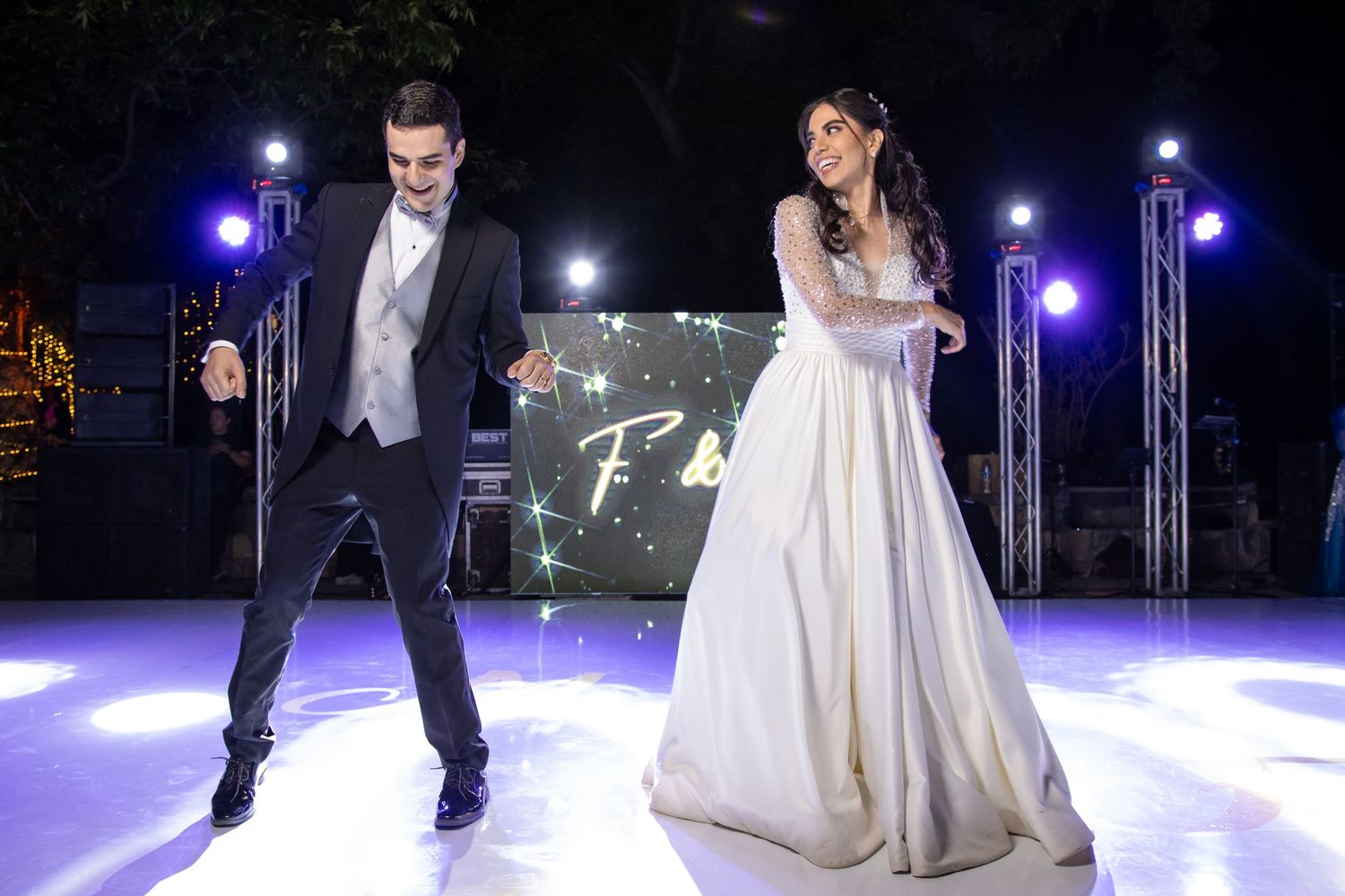 A lively wedding dance performance on an illuminated stage with theatrical lighting and effects. Boda en Parras Coahuila, Fotógrafo de bodas