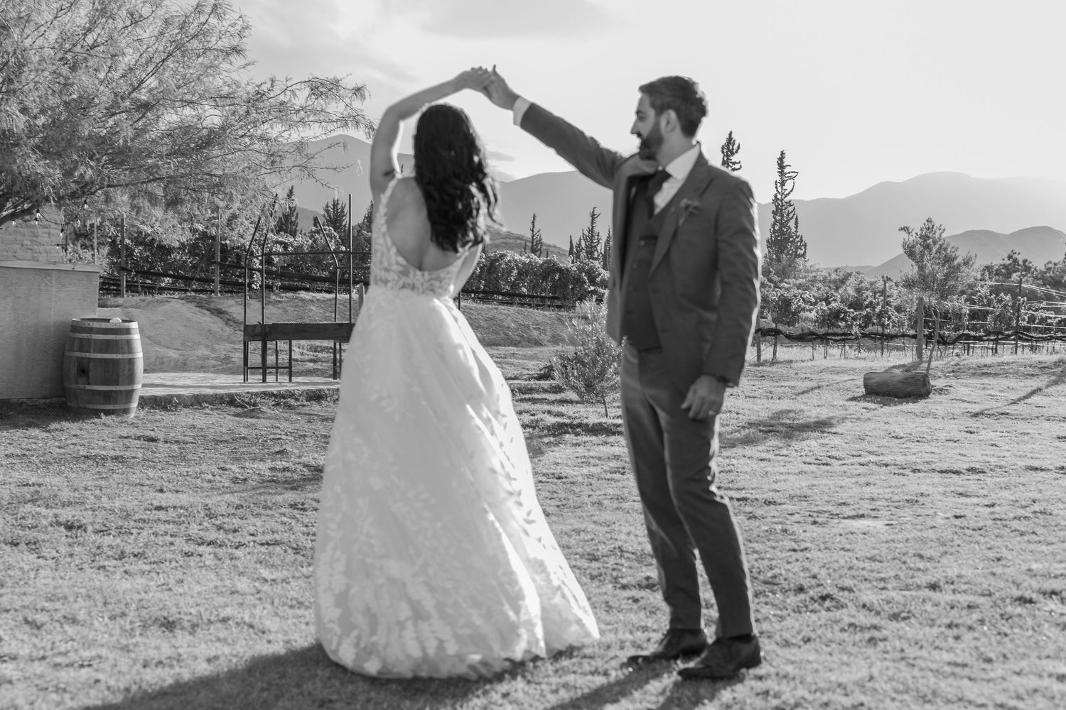 A romantic black and white photo of a couple dancing outdoors with mountains in the background. Boda en Parras Coahuila fotógrafo