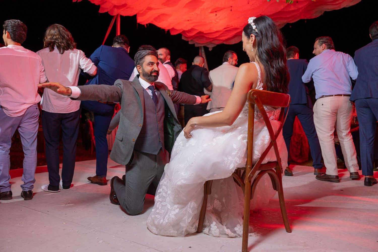 Traditional wedding moment on an illuminated dance floor under a red-draped tent. Boda en Parras Coahuila fotógrafo