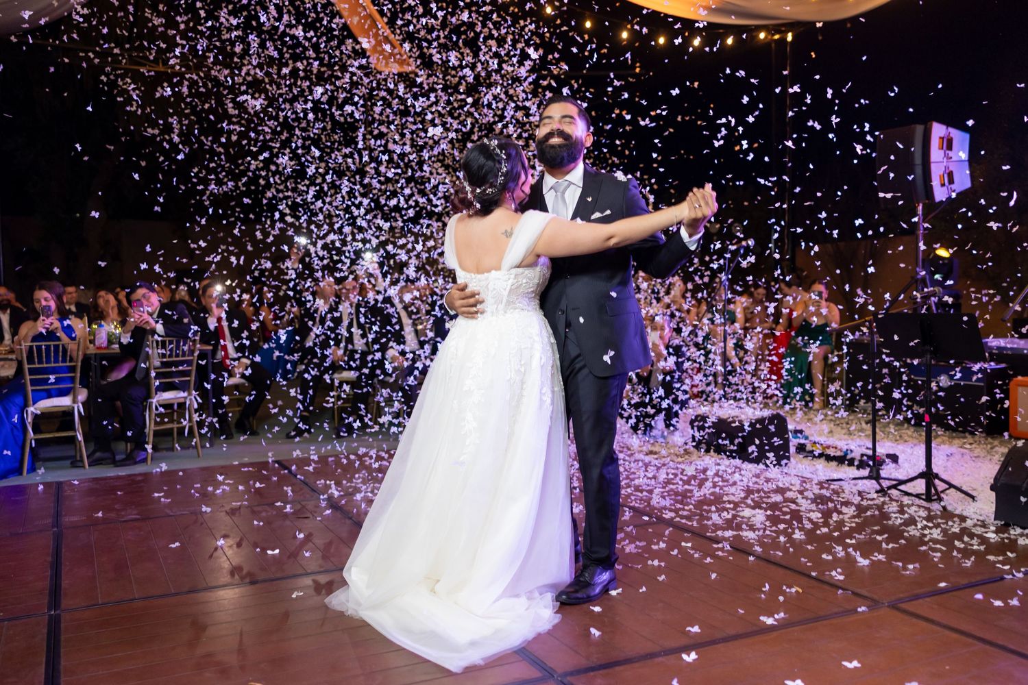 Wedding couple dances amid falling white confetti during reception. Boda en Parras Coahuila, Fotógrafo de bodas