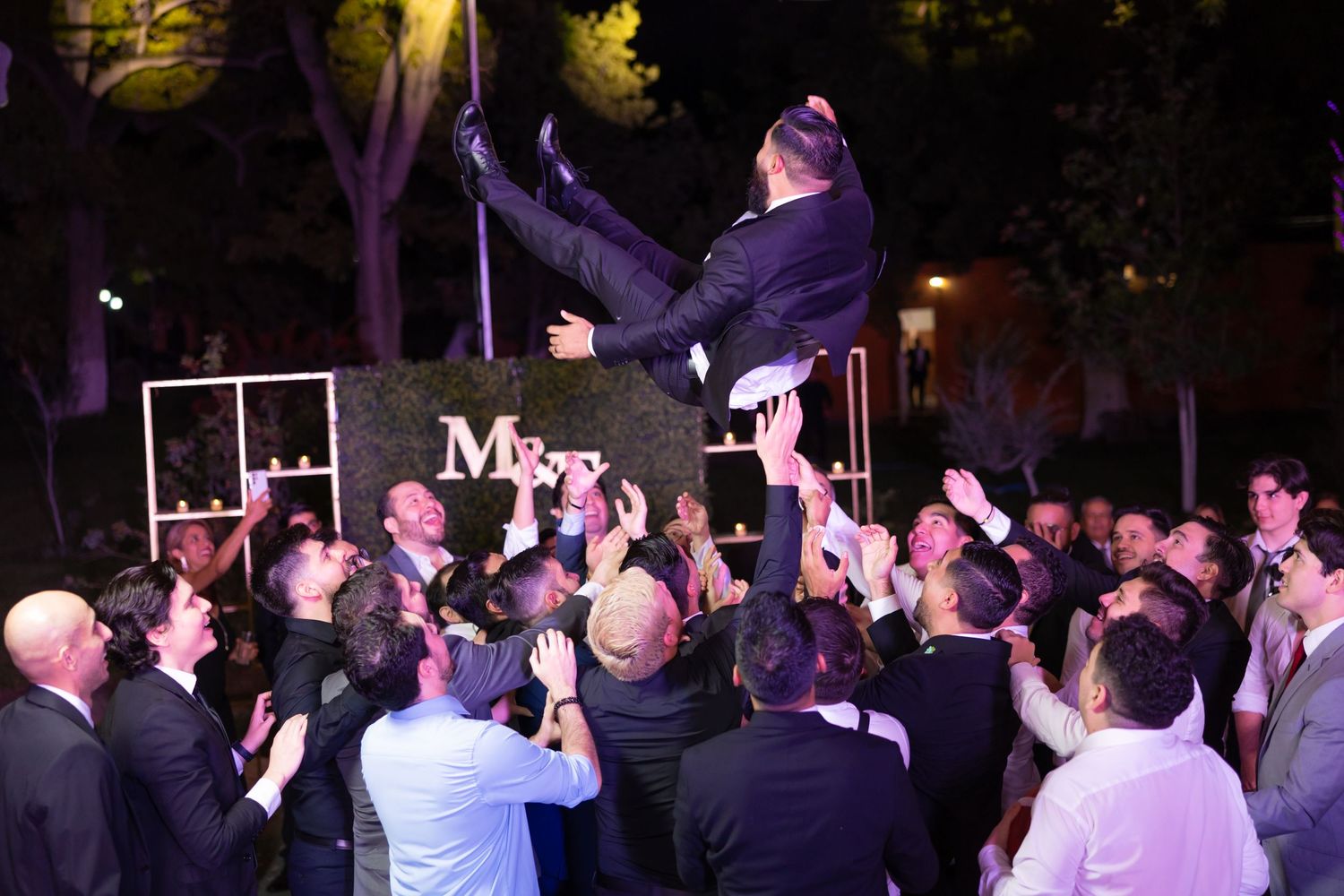 Night celebration with guest being lifted up by crowd during outdoor wedding reception.Boda en Parras Coahuila, Fotógrafo de bodas,