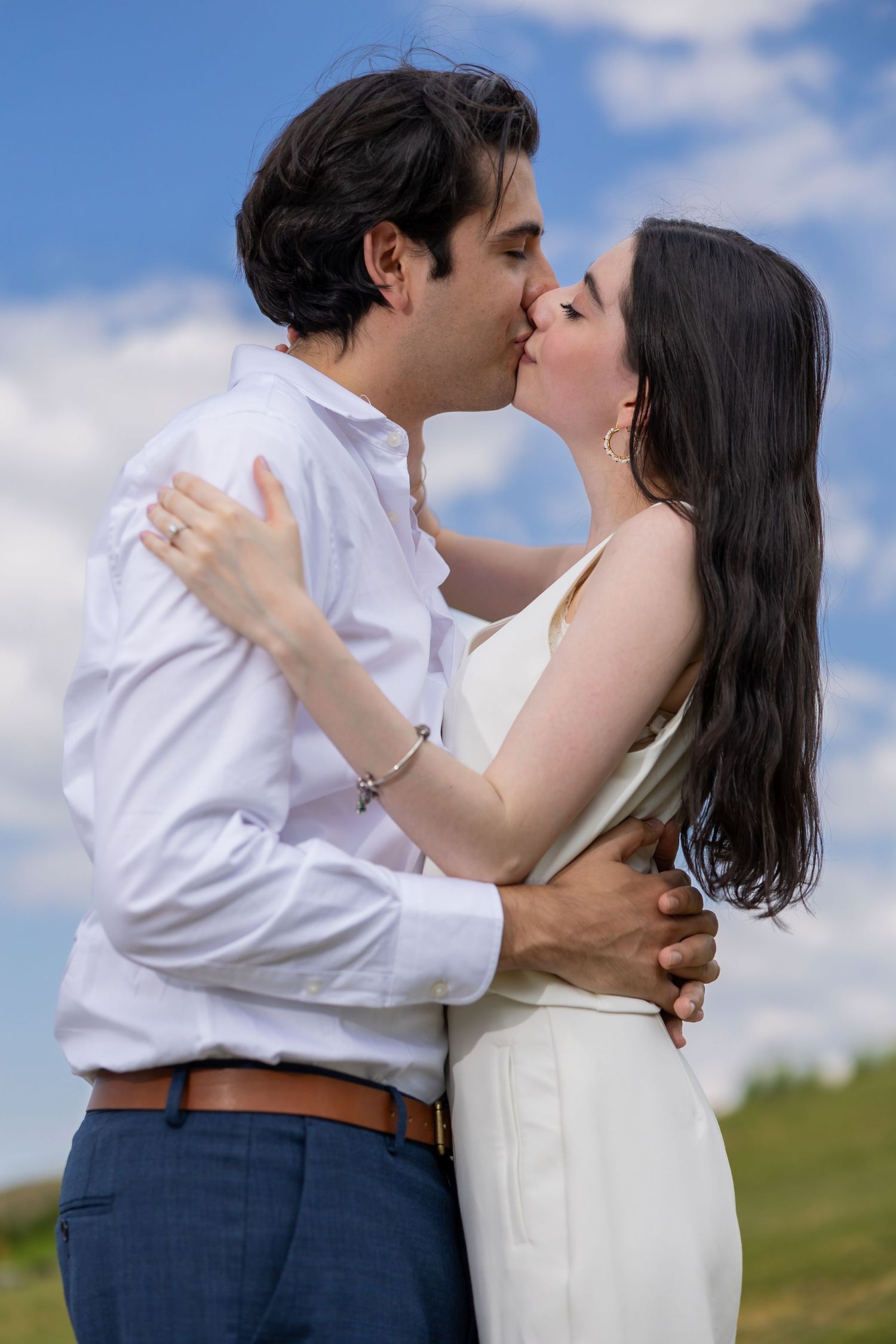 A romantic outdoor kiss between a couple with blue sky and clouds in the background. Propuesta de matrimonio Parras, Fotografo