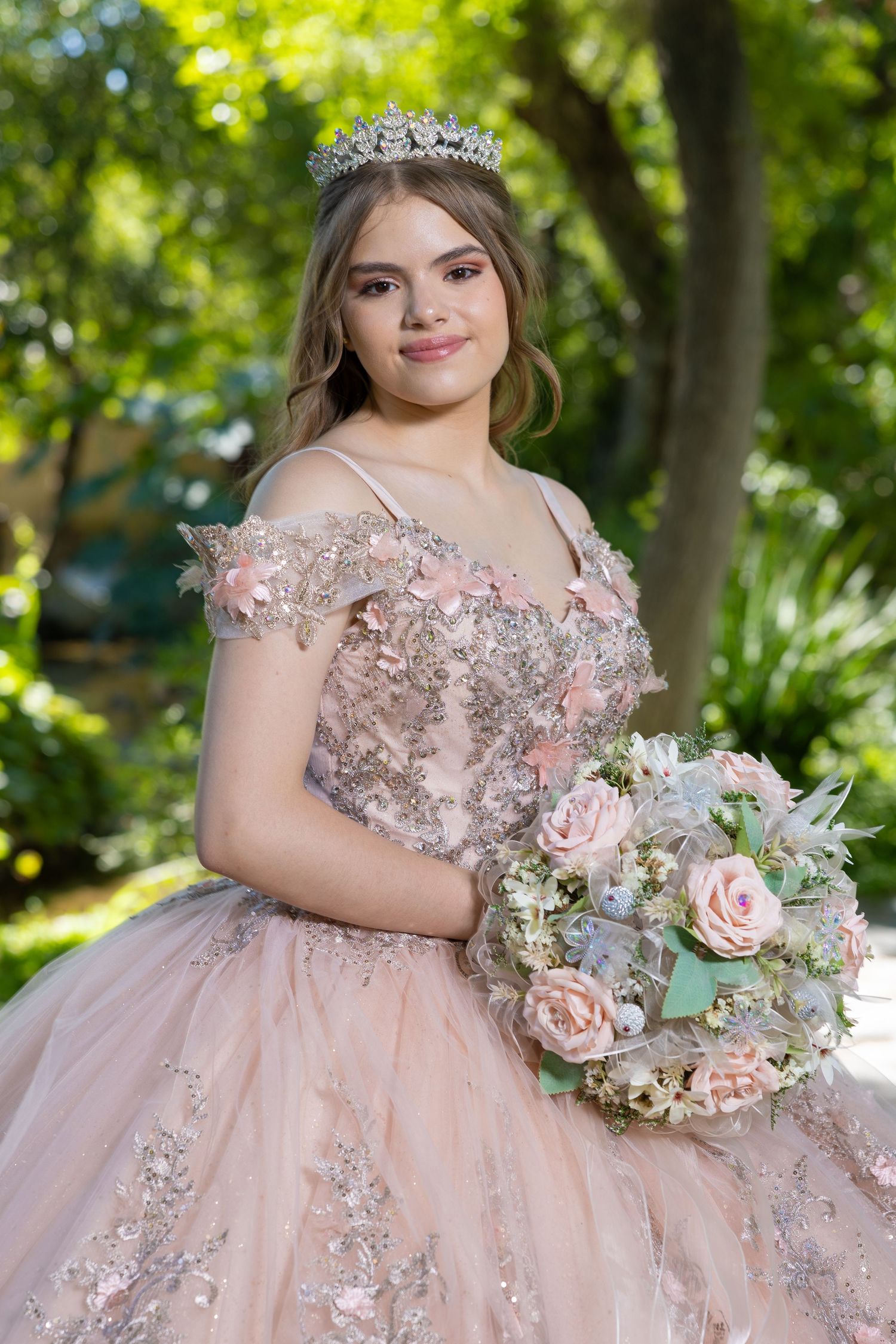 A romantic blush pink quinceañera gown adorned with floral appliques and crystals in a garden setting. Evento en Parras Coahuila , Foto