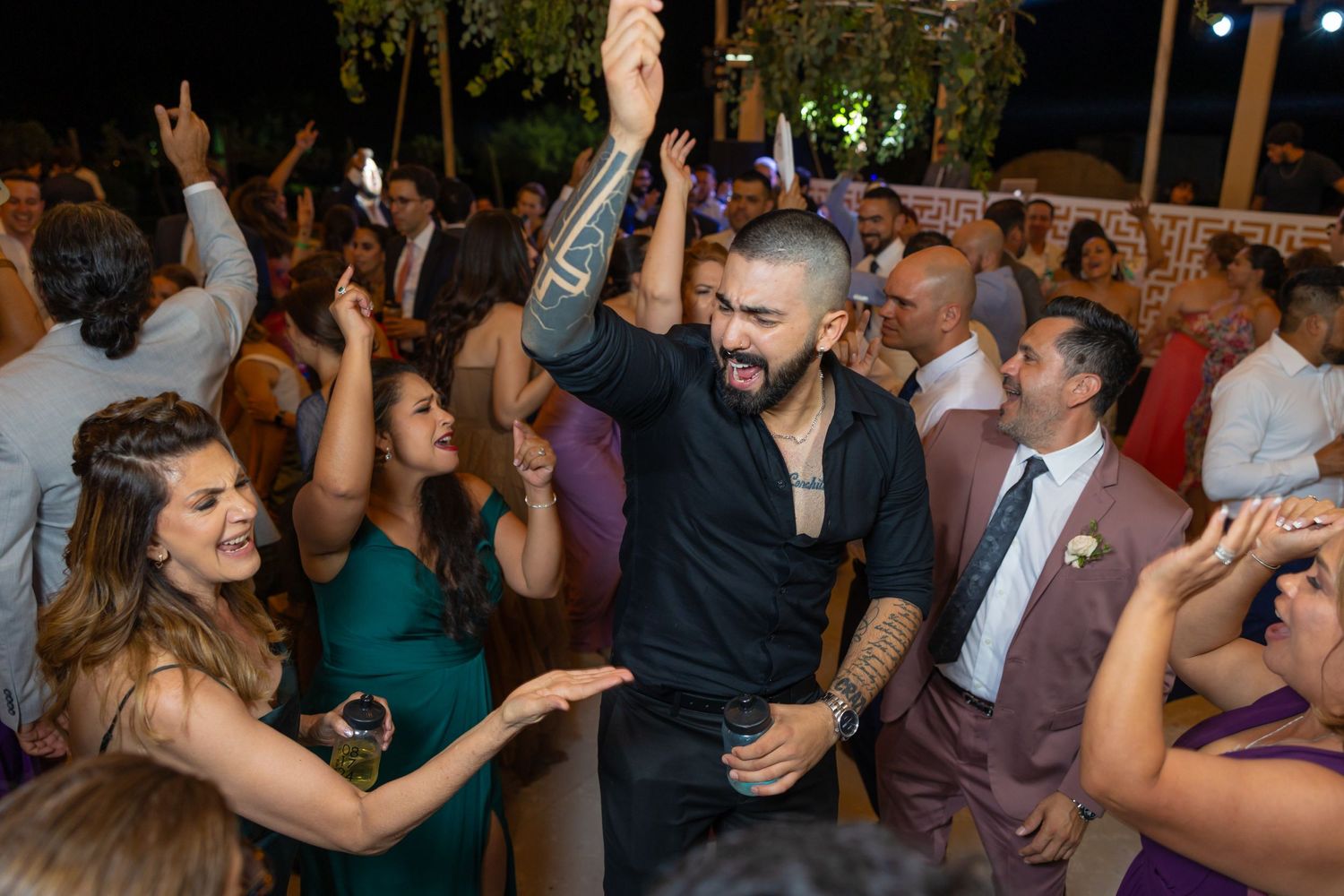 Party guests dancing energetically at a festive wedding celebration. Boda en Parras Coahuila fotógrafo