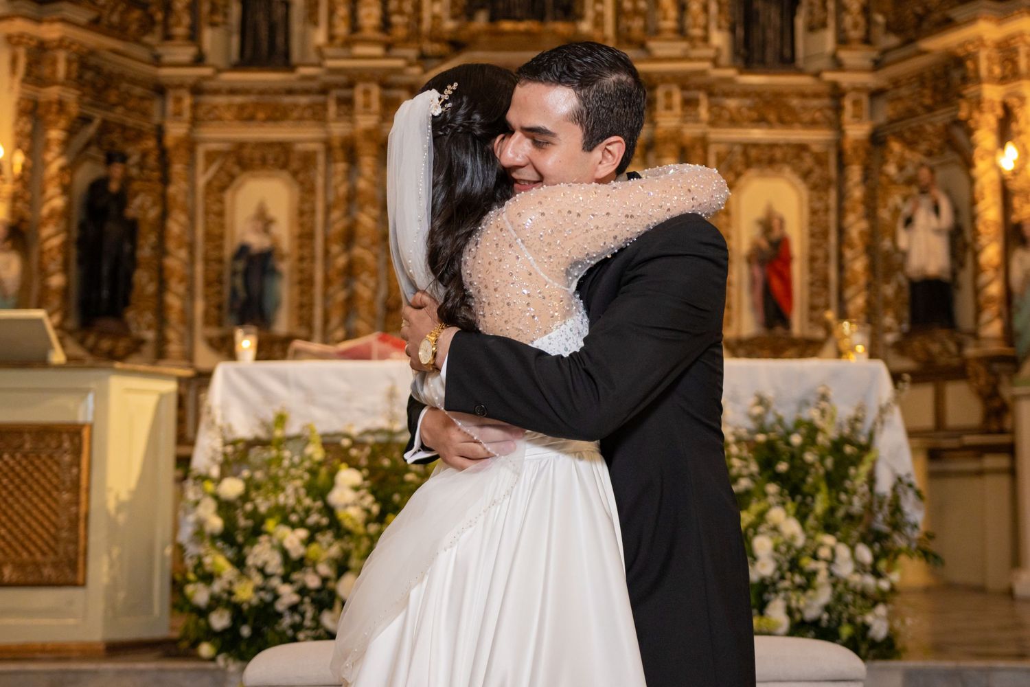 A newlywed couple embraces at the altar after their church wedding ceremony. Boda en Parras Coahuila, Fotógrafo de bodas