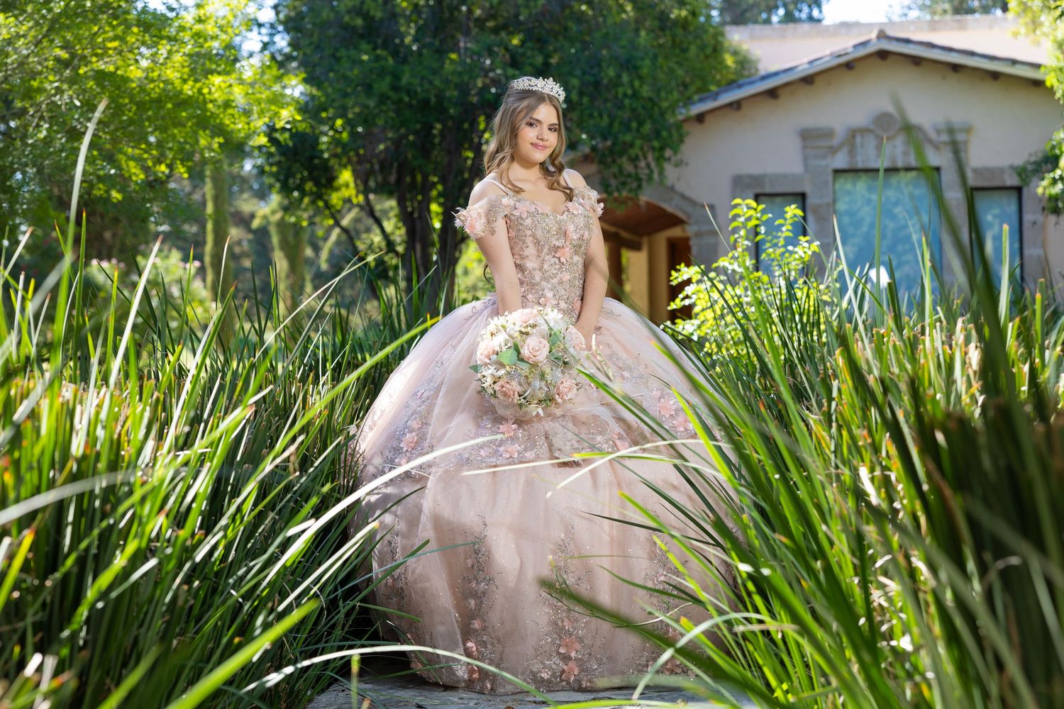 An elegant ball gown photographed in a lush garden setting with tropical foliage. Evento en Parras Coahuila , Fotógrafo Rulo