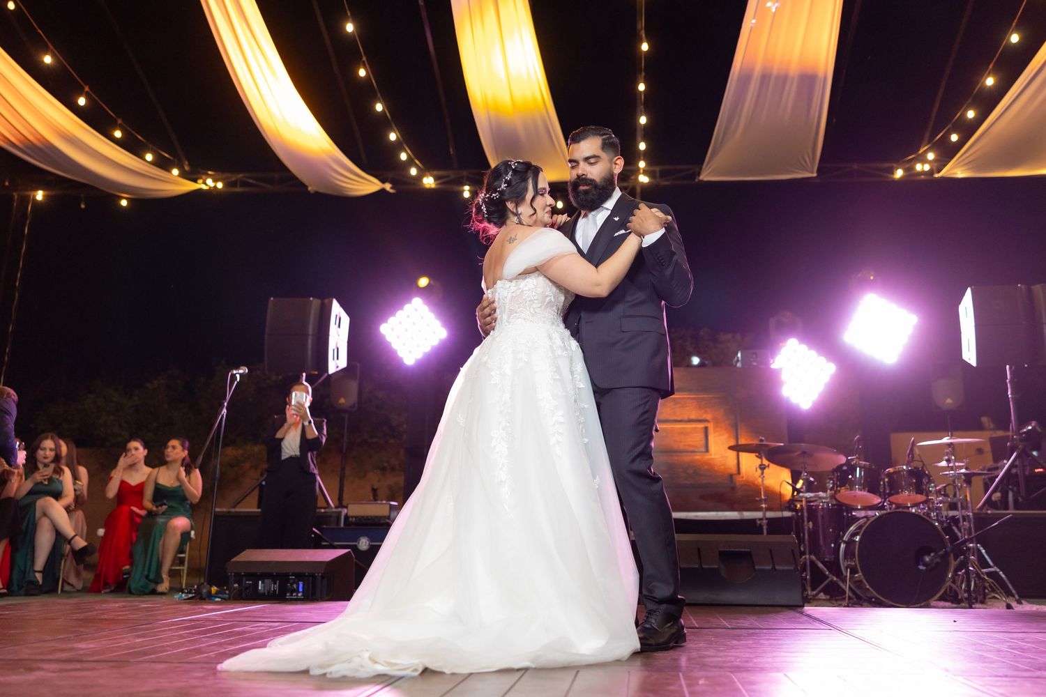 Romantic first dance under draped fabric ceiling and string lights at elegant wedding reception. Boda en Parras Coahuila, Fotógrafo de bodas