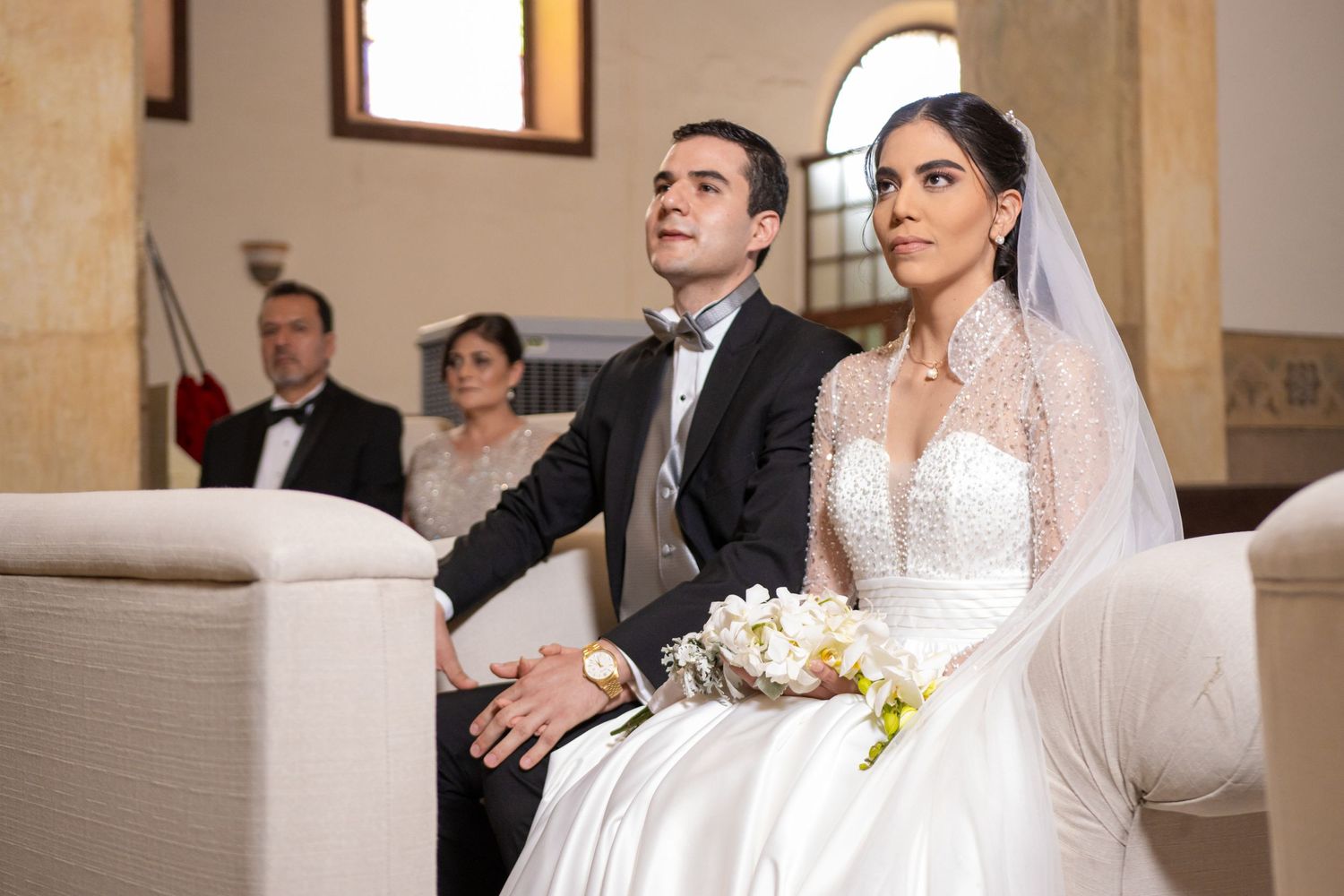 Wedding couple seated during traditional Catholic church ceremony. Boda en Parras Coahuila, Fotógrafo de bodas