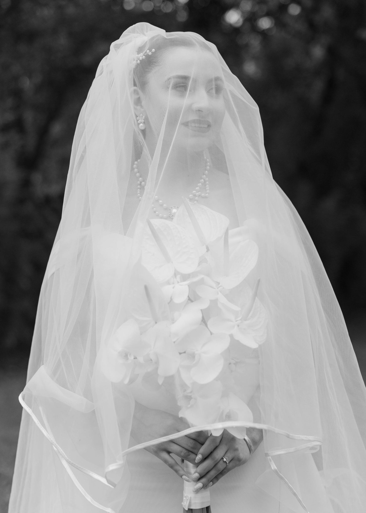 A series of black and white bridal portraits showing a bride in a veil with different expressions and poses.