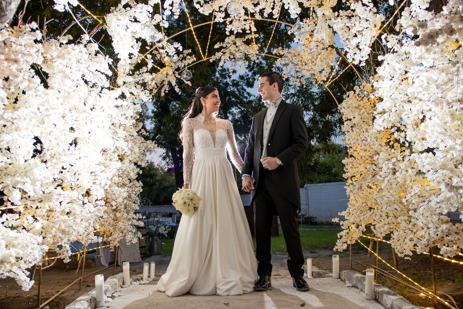 Elegant wedding ceremony setup with glowing arch and white floral decorations. Boda en Parras Coahuila, Fotógrafo de bodas