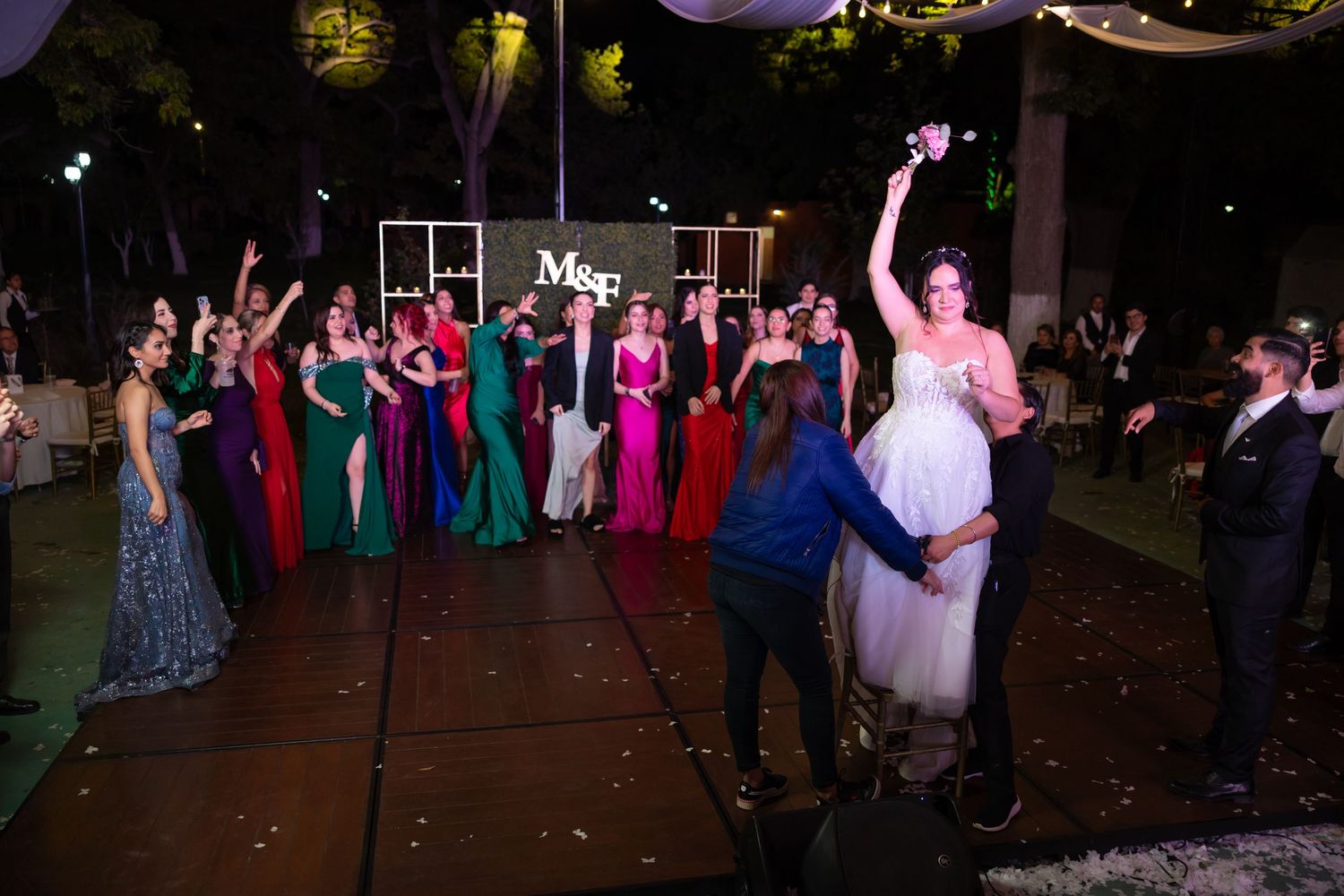 Colorful wedding reception dance party with guests in formal attire under outdoor lighting. Boda en Parras Coahuila, Fotógrafo de bodas,