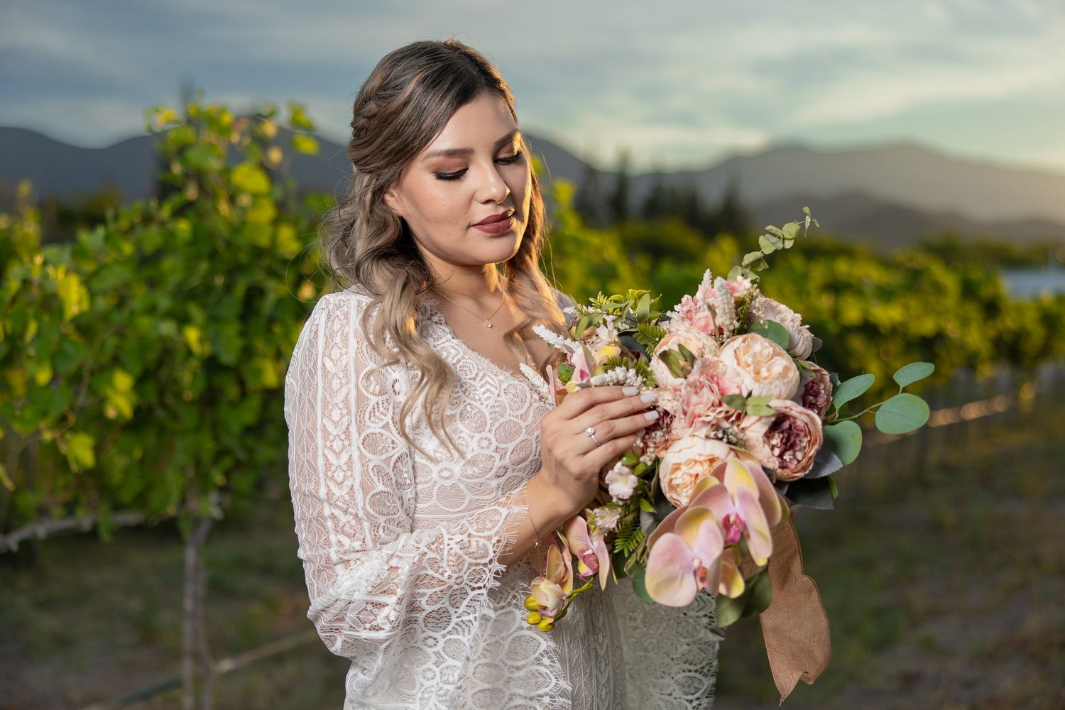 A beautiful bouquet of pink roses and eucalyptus held in a vineyard setting. Boda en Parras Coahuila fotógrafo