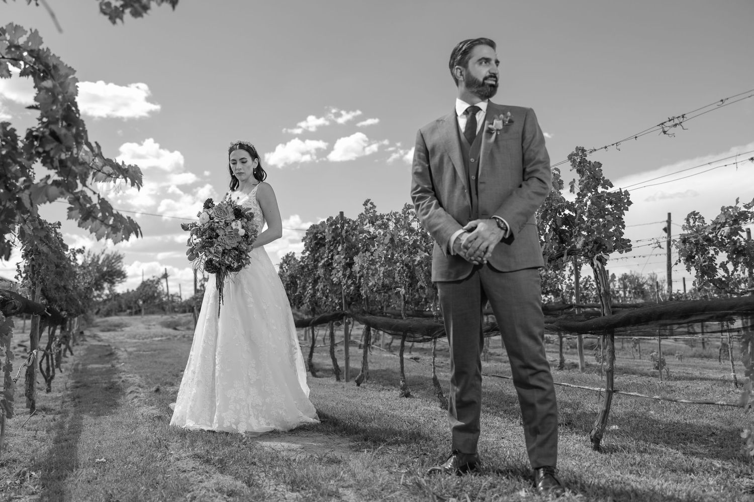 A black and white wedding portrait in a vineyard setting with dramatic sky. Boda en Parras Coahuila fotógrafo