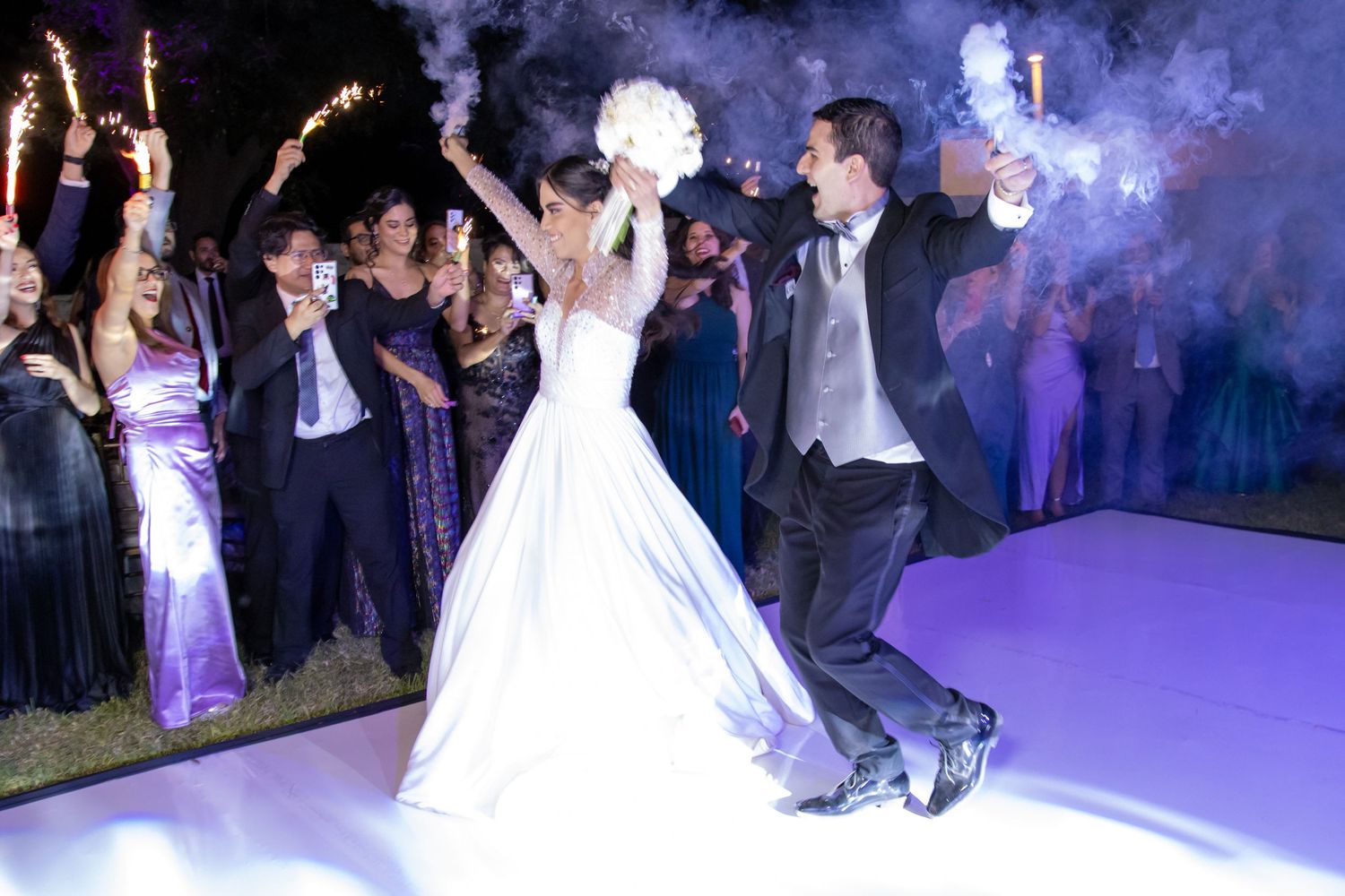 Energetic wedding dance celebration with purple smoke effects and sparklers. Boda en Parras Coahuila, Fotógrafo de bodas