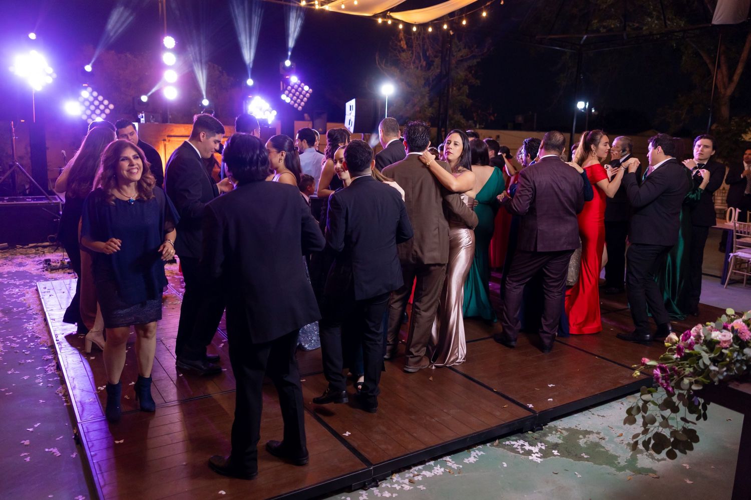 Wedding guests dance and socialize on an illuminated outdoor dance floor at night. Boda en Parras Coahuila, Fotógrafo de bodas