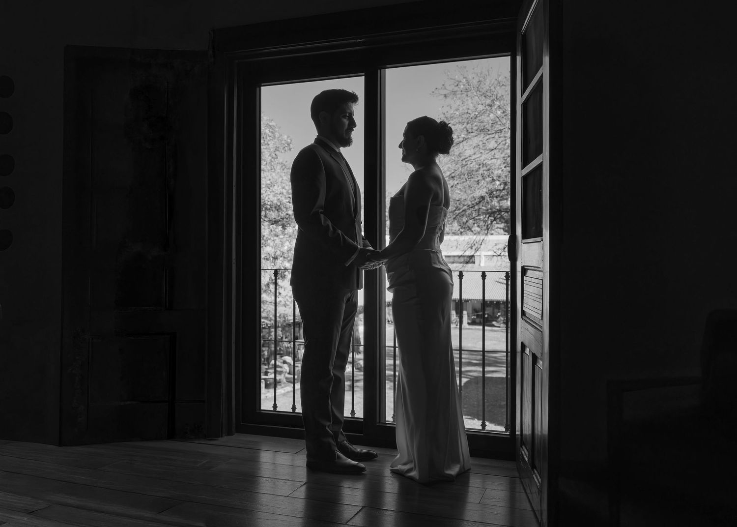 Silhouetted figures stand in dark doorways creating a dramatic black and white composition.