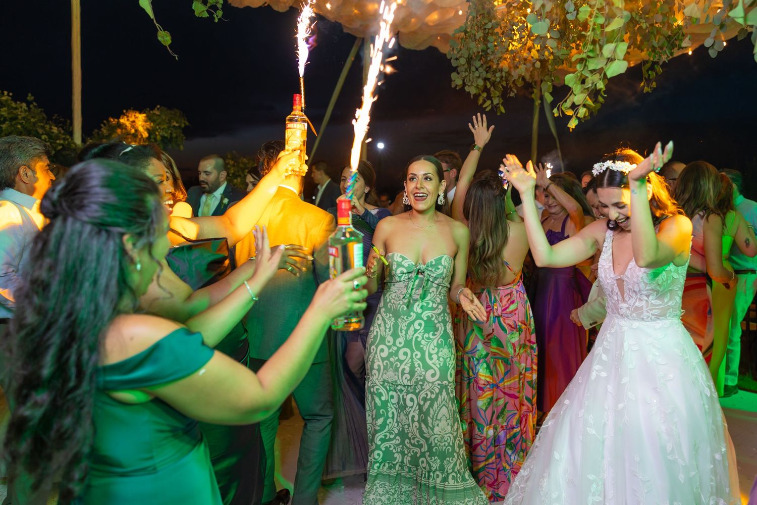 Wedding guests dance and celebrate with sparklers at a nighttime reception. Boda en Parras Coahuila fotógrafo