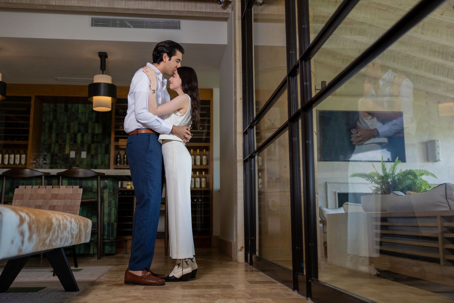A stylishly dressed couple shares an intimate moment in a modern interior space. Propuesta de matrimonio Parras, Fotografo