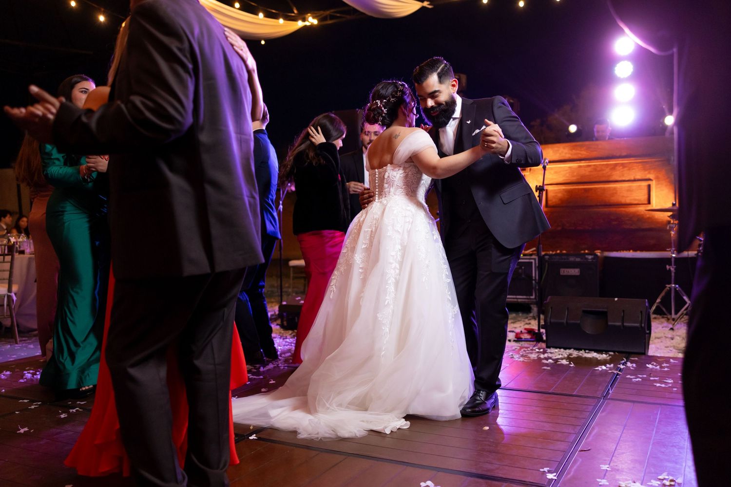 Wedding couple dances on stage near a piano during their evening reception. Boda en Parras Coahuila, Fotógrafo de bodas