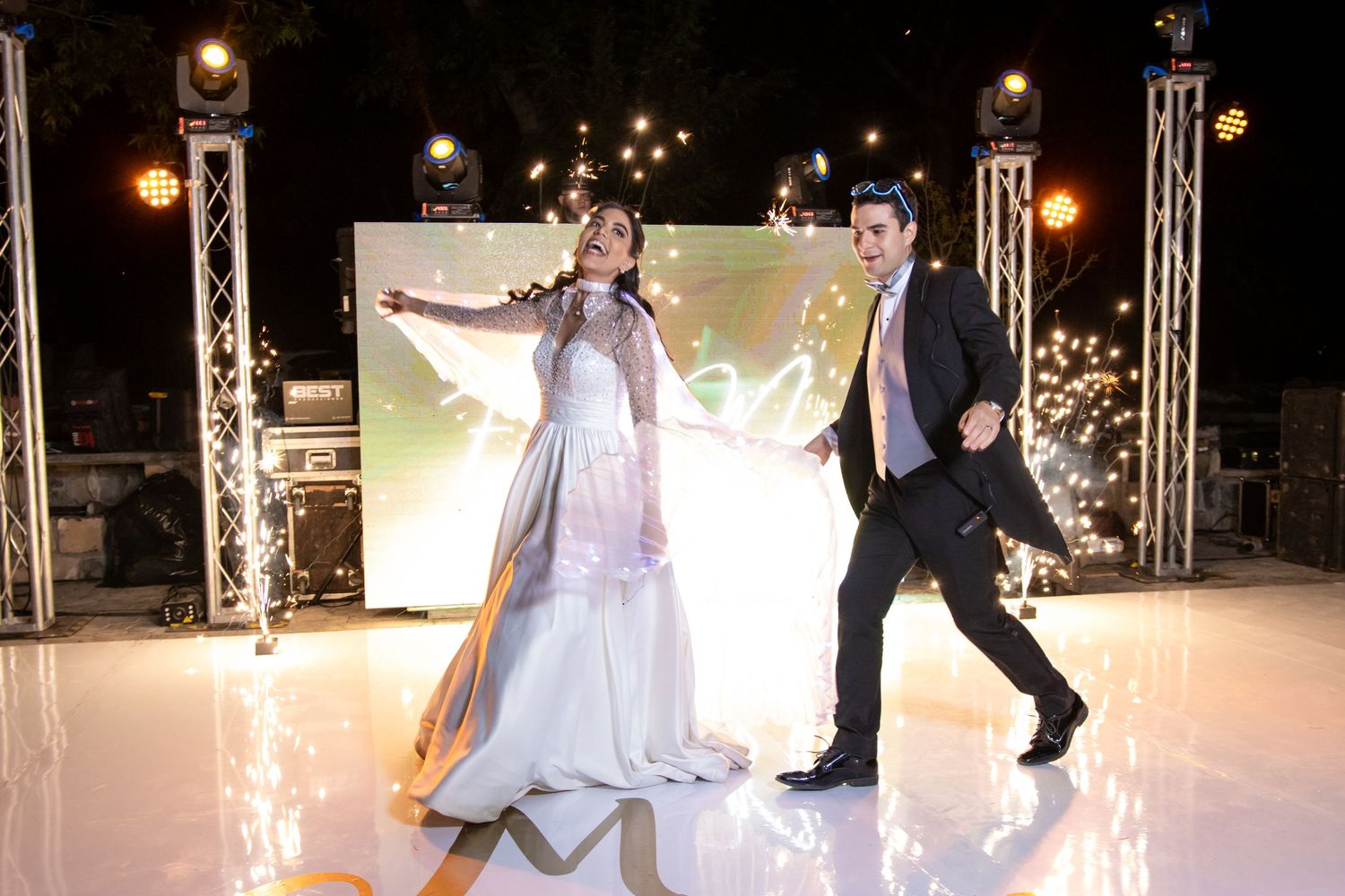 Dancing couple performs on an illuminated outdoor dance floor with stage lighting. Boda en Parras Coahuila, Fotógrafo de bodas