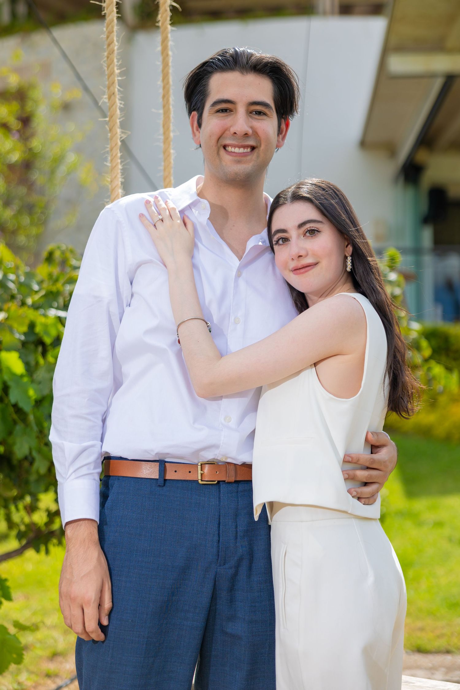 A couple in coordinated white and blue outfits poses in a garden setting. Propuesta de matrimonio Parras, Fotografo