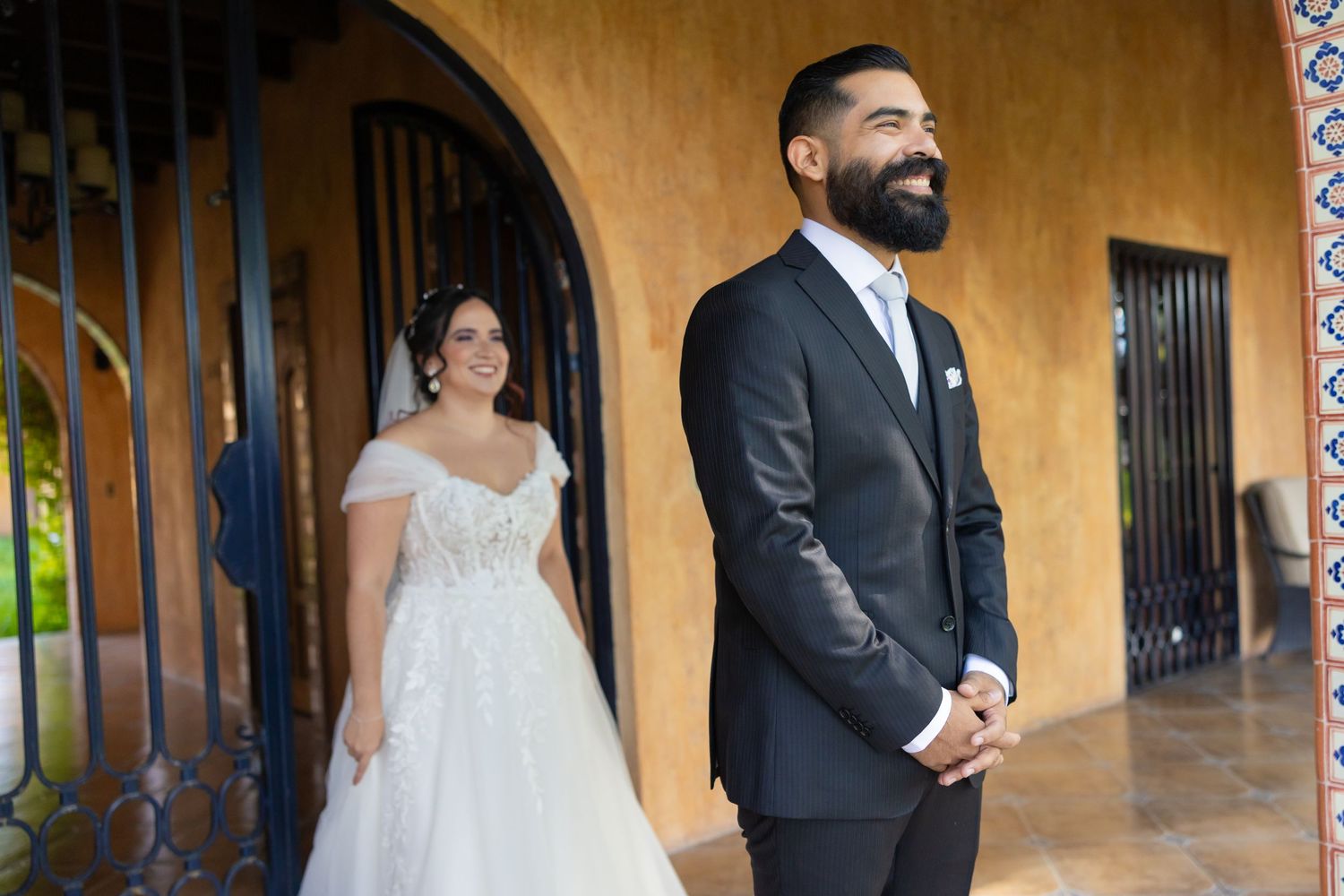 A wedding couple poses against a yellow stucco wall with arched doorways. Boda en Parras Coahuila, Fotógrafo de bodas
