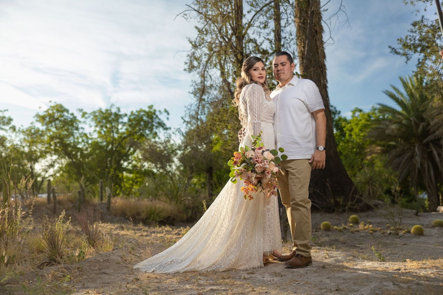 Romantic wedding portrait with couple holding colorful bouquet in natural outdoor setting. Sesión en Parras Coahuila