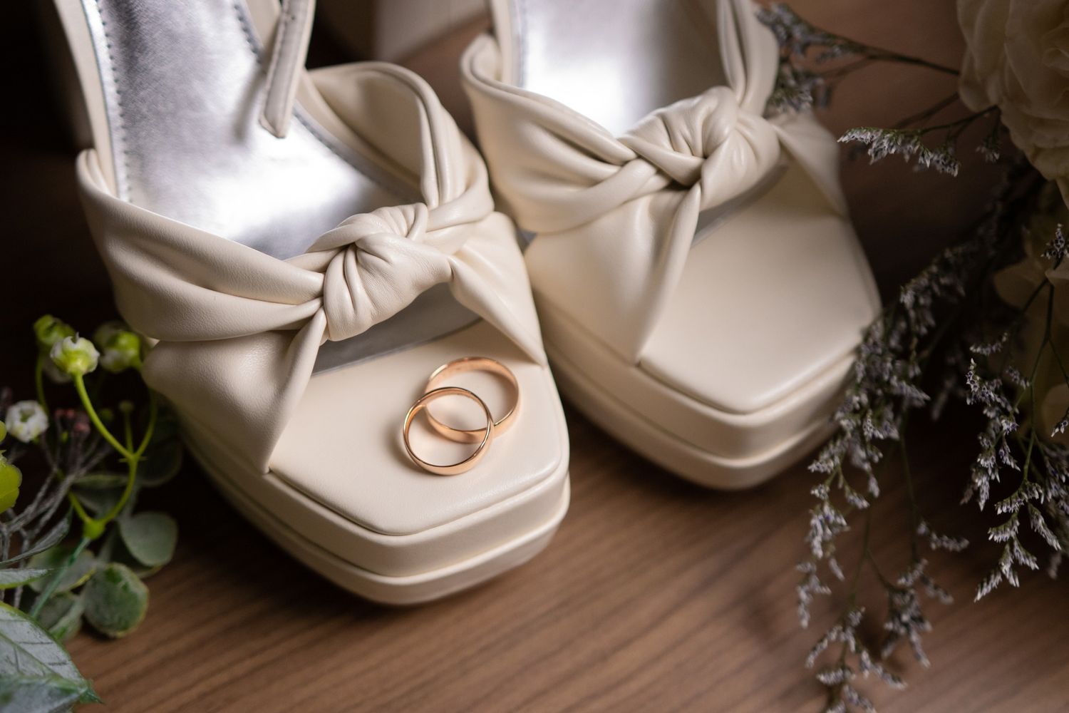 Wedding rings placed elegantly on white satin platform shoes. Boda en Parras Coahuila fotógrafo