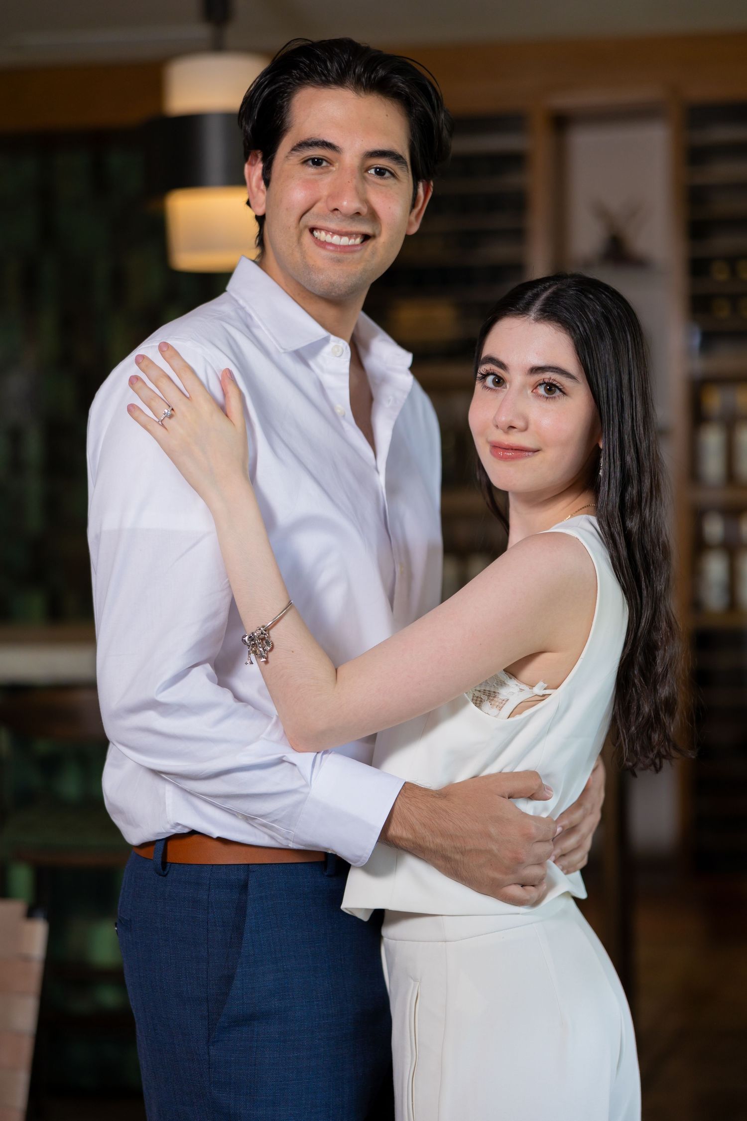 A romantic couple embraces while dressed in complementary white and blue formal attire indoors. Propuesta de matrimonio Parras, Fotografo en