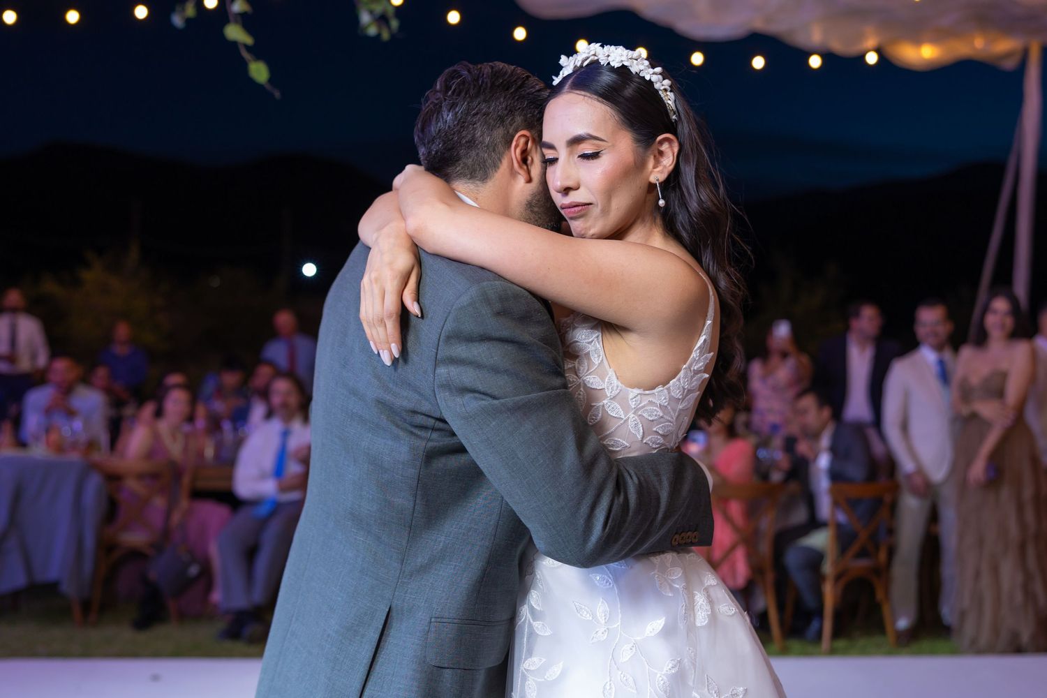 A romantic first dance at an outdoor evening wedding reception with string lights. Boda en Parras Coahuila fotógrafo