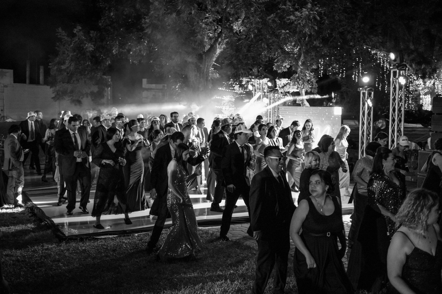 Black and white photo of people dancing at an outdoor wedding reception. Boda en Parras Coahuila, Fotógrafo de bodas