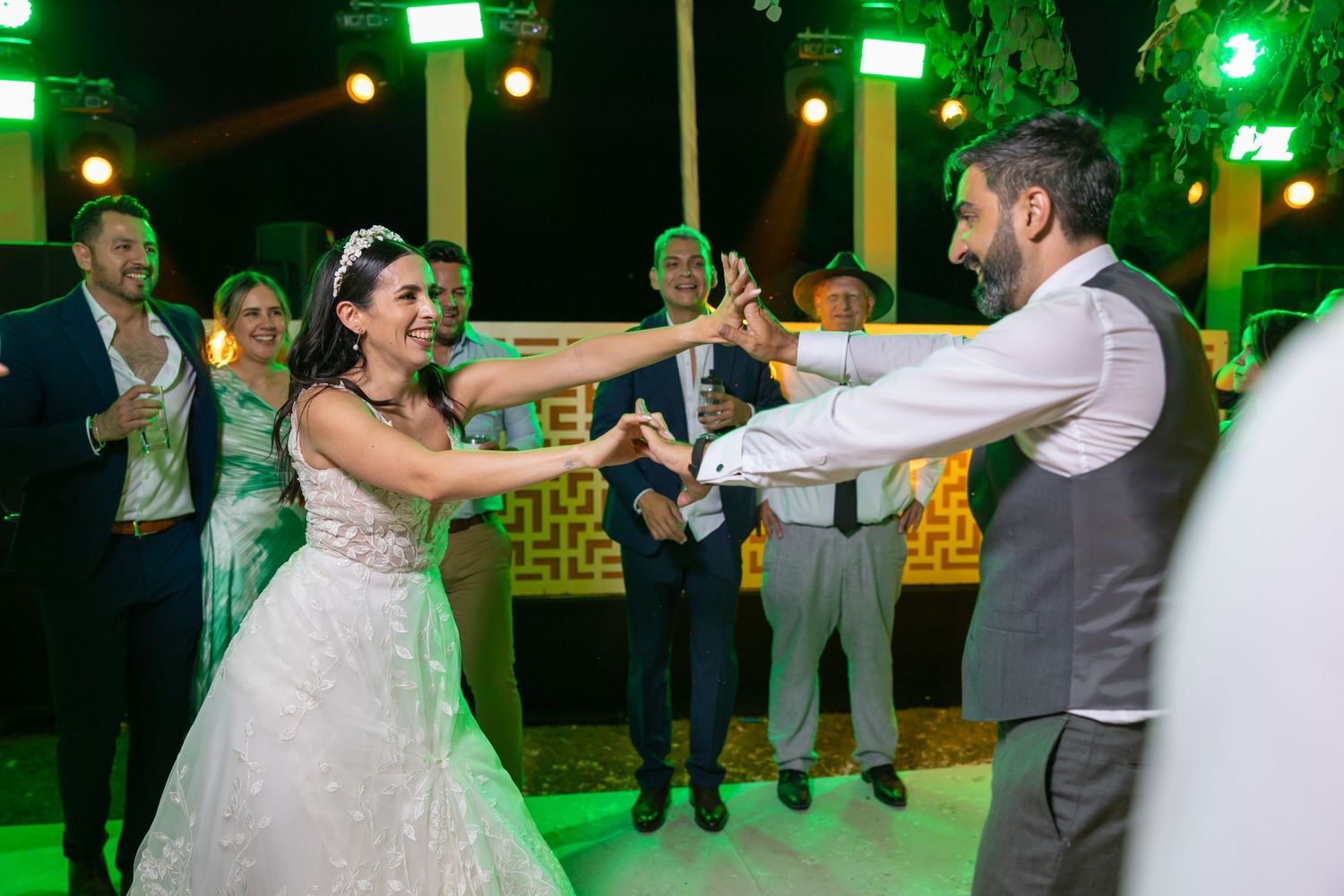 Couple performing synchronized dance moves on illuminated green dance floor. Boda en Parras Coahuila fotógrafo