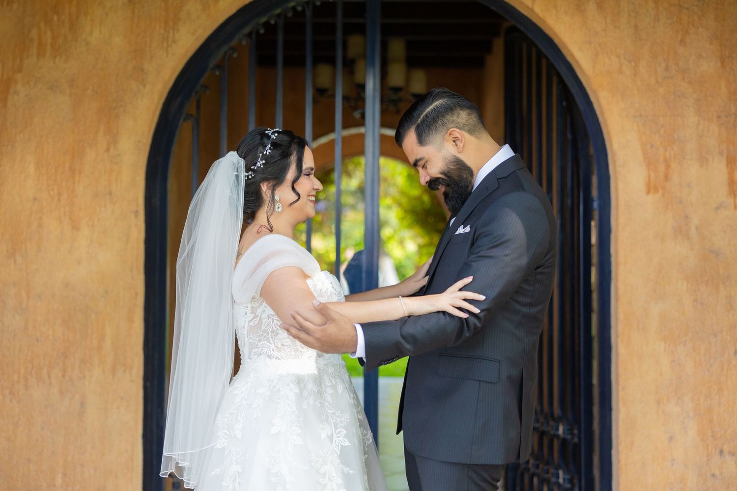 A tender wedding moment shared between a couple in front of an arched doorway. Boda en Parras Coahuila, Fotógrafo de bodas