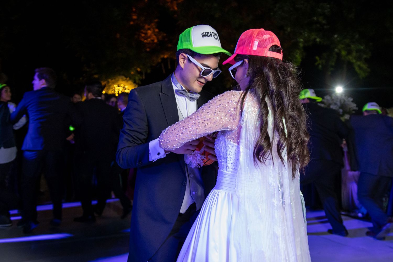 A couple shares a dance while wearing playful baseball caps at their evening wedding reception. Boda en Parras Coahuila, Fotógrafo de bodas
