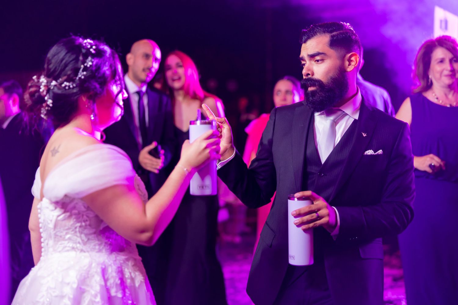 Wedding guests enjoy drinks together on a purple-lit dance floor during the reception celebration. Boda en Parras Coahuila, Fotógrafo